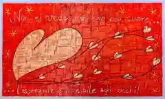 Opera di Valentina Mammana: grande cuore color crema su fondo rosso, da cui partono steli con piccoli cuori e stelle gialle, con la citazione «Non si vede bene che col cuore, l’essenziale è invisibile agli occhi»