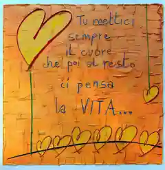 Opera di Valentina Mammana: cuori gialli dal bordo rosso su steli verdi e una fila di cuori in basso, su fondo arancio, con la scritta blu «Tu mettici sempre il cuore, che poi al resto ci pensa la vita»